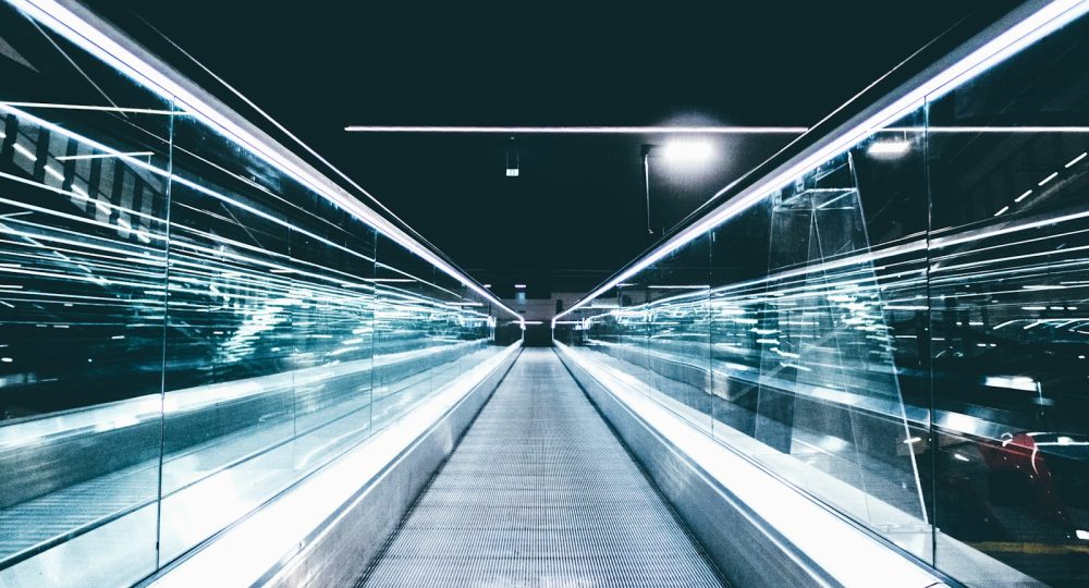 gray conveyor between glass frames at nighttime