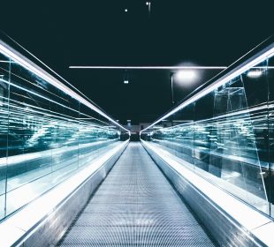 gray conveyor between glass frames at nighttime